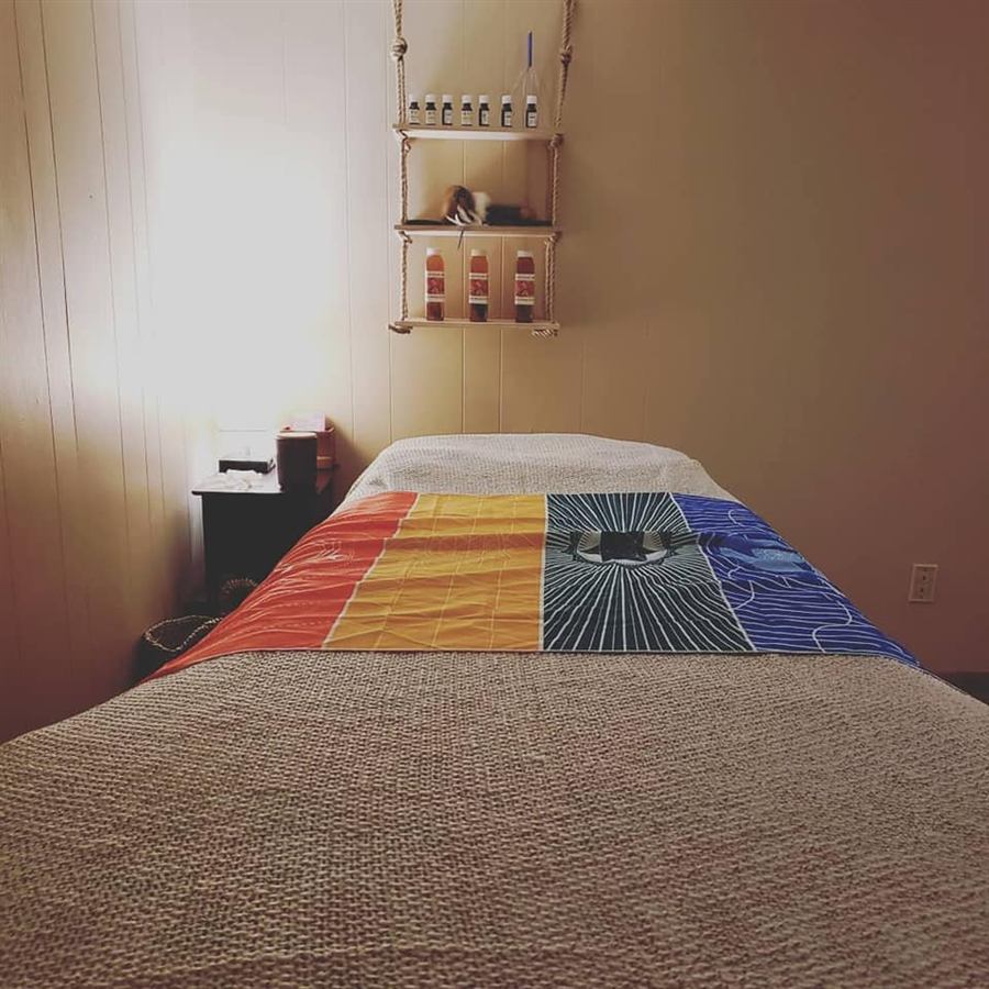 Treatment table with a rainbow chakra blanket